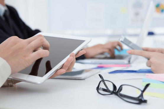 personas reunidas con tablets en la mano